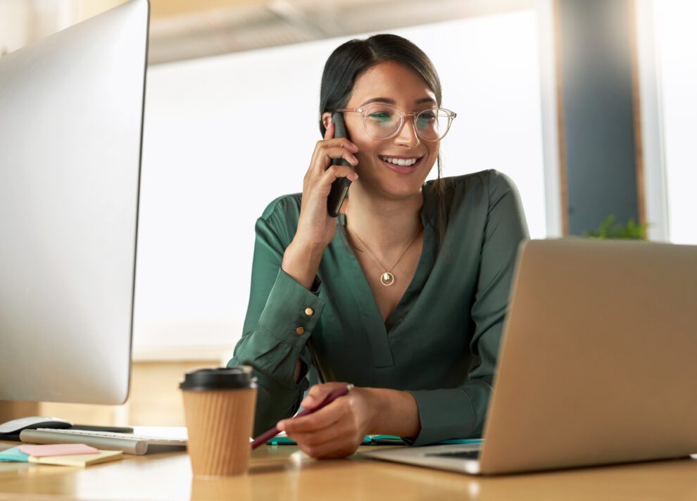 TWIMM 40 Femme au téléphone à son bureau devant son ordinateur, dans un environnement de travail.