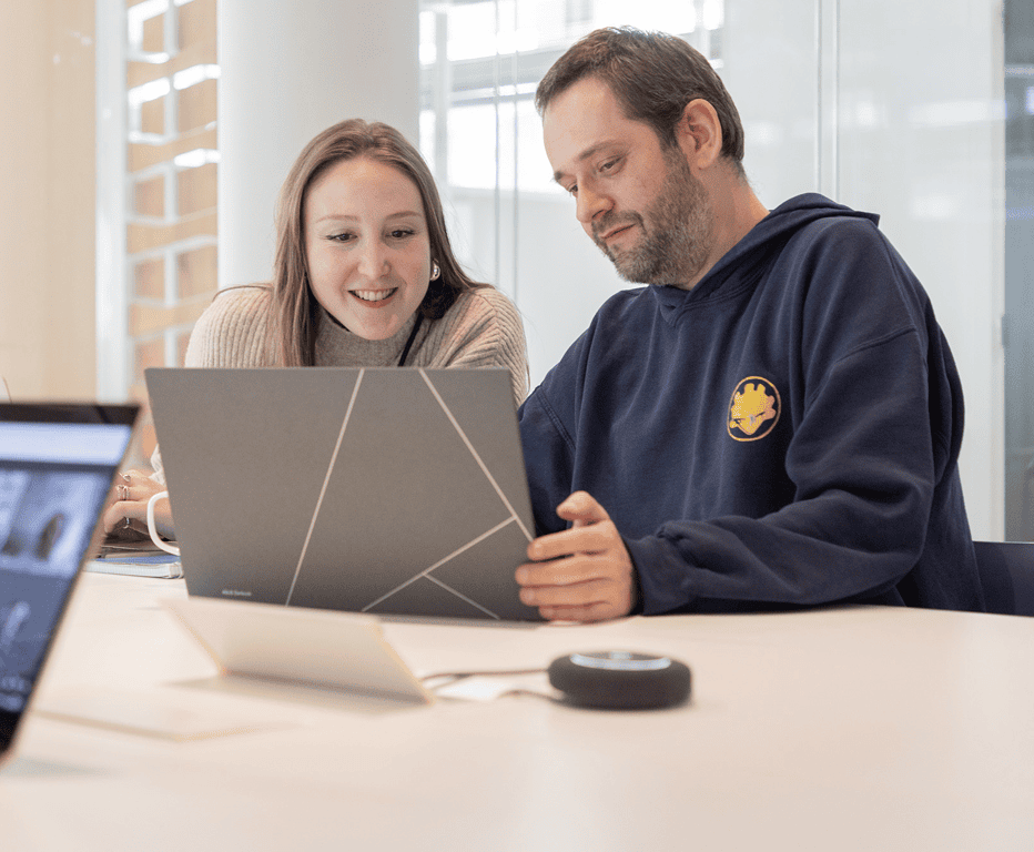 Deux collaborateurs de Twipi Group devant un ordinateur portable, avec une visioconférence en cours.