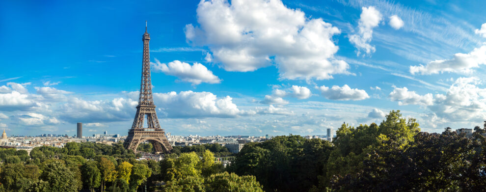 La tour Eiffel à Paris sous un ciel bleu, vue panoramique depuis les jardins.