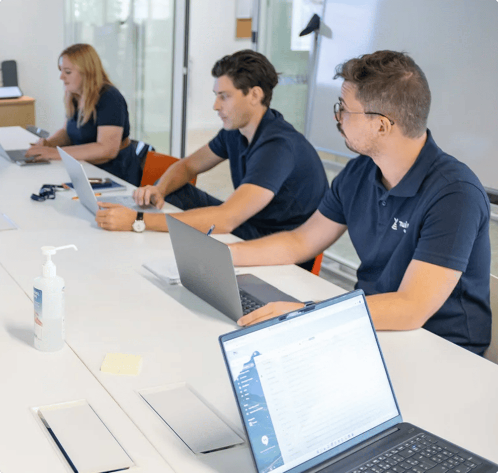 Collaborateurs de Twipi Group au travail sur leurs ordinateurs portables, illustrant l'équipe dédiée.