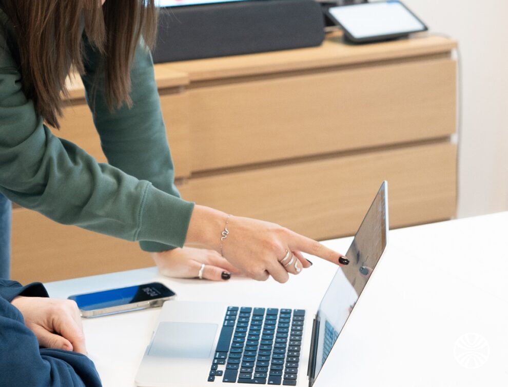 Nous rejoindre 6 Collaboratrice désignant un élément à l'écran d'un ordinateur portable à un collègue.